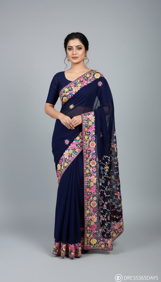 Navy blue parsi gara saree with floral patterns on a mannequin against a textured wall.